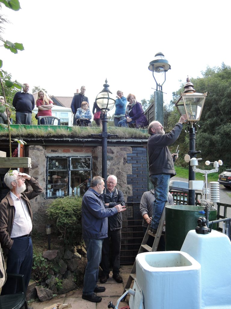 Brian Harper of Sight Designs lights a gas lamp powered by the dog poo biodigester.