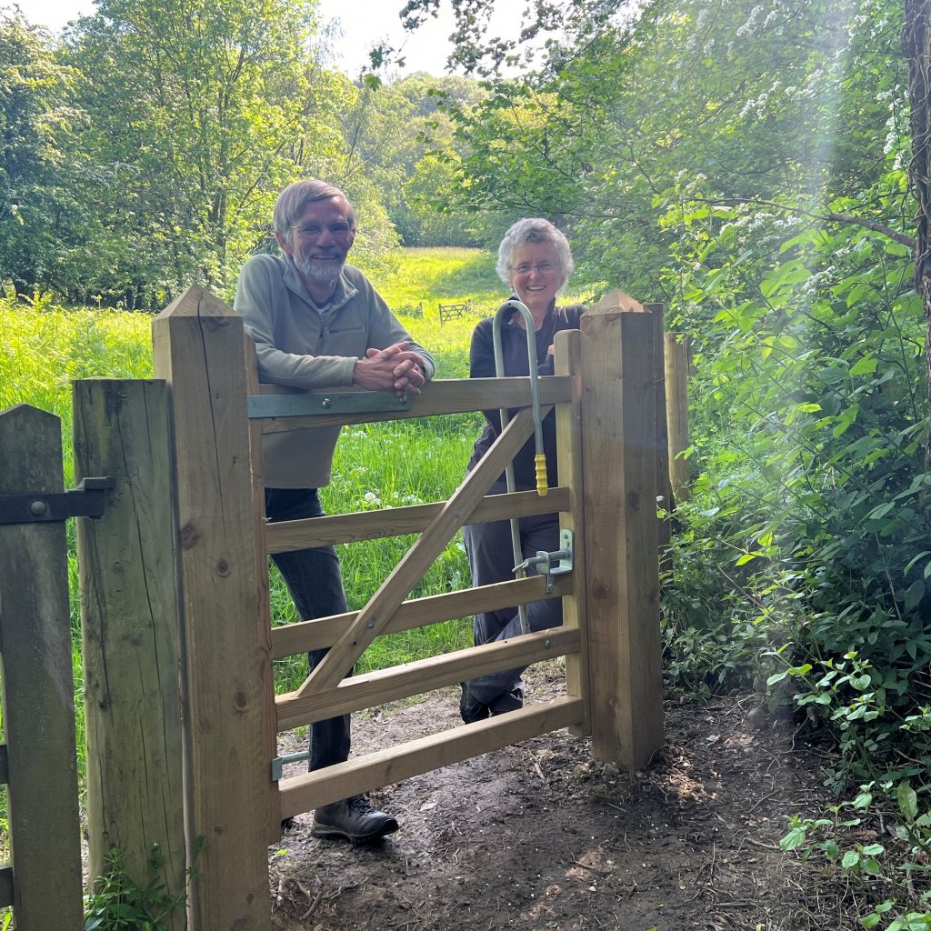 Couple leaning on new access gate on MHT land